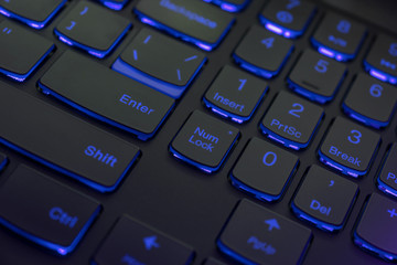 Colorful keyboard for gaming. Backlit keyboard with blue color scheme. Colorful light keyboard