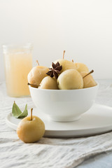 Pickled apples in bowl and apple sidr on white stone table.