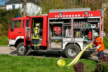 Feuerwehreinsatz mit Feuerwehrfahrzeug und Feuerwehrmännern