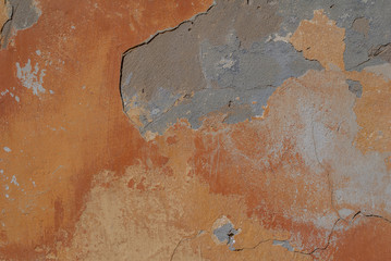 surface of the old wall with exfoliating and falling off paint as a background or texture, orange...