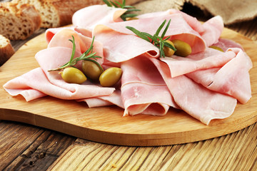 Sliced ham on wooden background. Fresh prosciutto. Pork ham sliced.