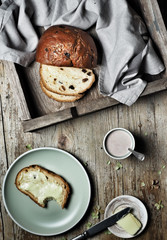 Sweet bread, typical Slovak cake. A cup of cocoa milk and piece of butter on plate on vintage wooden background. Overhead shot.