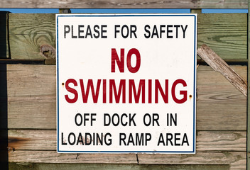Obraz premium Close view of a no swimming sign on a public pier.