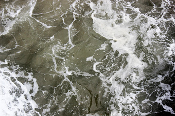 Naklejka premium Closeup of beach ocean foam water texture ripples splashing