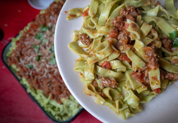 Tagliatelle Bolognese Flat strips of pasta served in homemade meat sauce on table.