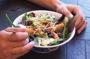 Adult male with fork in his salad bowl