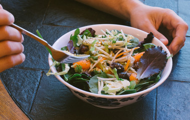 Adult male with fork in his salad bowl
