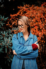 beautiful young girl in jacket in a park. Fall season time scene.