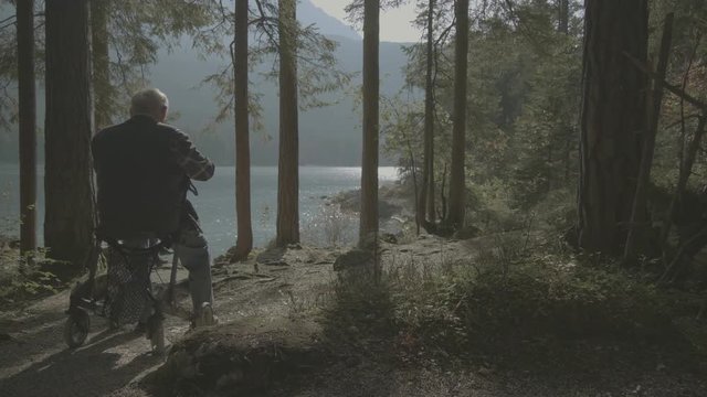 Senior mit Rollator blickt auf See