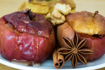 Baked apples with cinnamon and anise stars, stuffed with nuts and raisins, healthy food. Tasty christmas dessert. Close up. Macro.