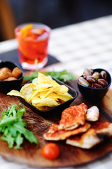 Glass of cocktail (sparkling wine with Aperol) and appetizer platter