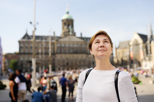 Mature woman standing on a Sunny autumn day in the Central dam square in the old city of Amsterdam.
