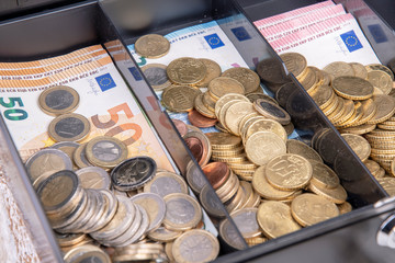 Cash box with coins and banknotes in Euro