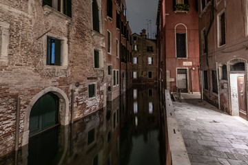 Fototapeta na wymiar A medieval canal in Venice with beautiful reflections