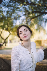 Beautiful girl in a white lace blouse in an autumn park