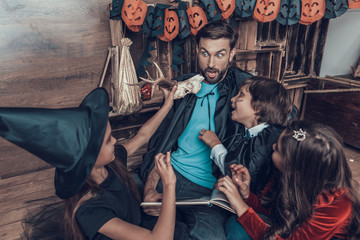 Man and Children in Halloween Costumes having Fun