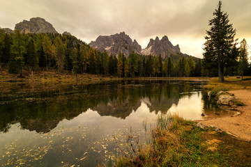 Cloudy morning at Antorno lake, warm morning colors and beautiful reflection. Italy, Europe