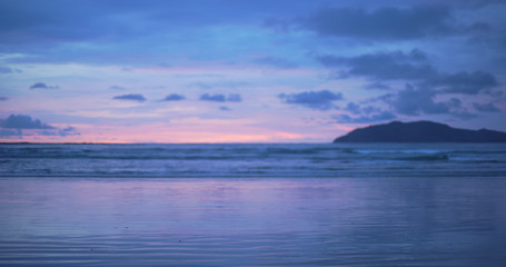 Fototapeta na wymiar Out of focus background plate of purple and blue sunset on Costa Rica beach