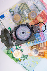 Compass with banknotes and coins