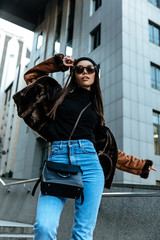 Fototapeta premium City style. Autumn/spring. Woman portrait. Stylish girl in casual clothes and sun glasses, outdoors
