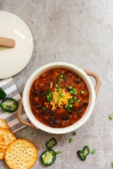 Homemade Vegetarian Bean Chili with crackers, overhead view