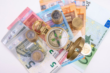 golden compass with banknotes and coins