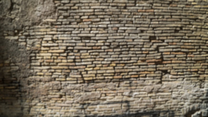 Defocused background plate of brown cobble stone wall in European city
