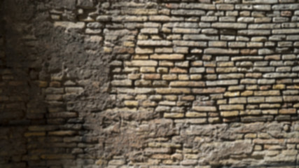 Defocused background plate of brown cobble stone building wall