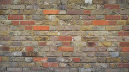 Fototapeta premium Close up of multicolored brick wall texture with scratches
