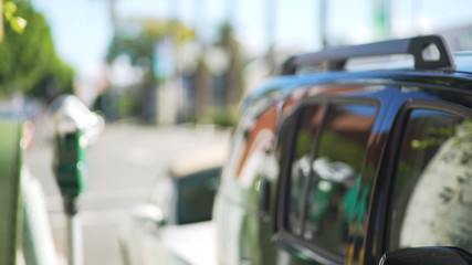 View of urban traffic behind a blurred car and parking meter downtown