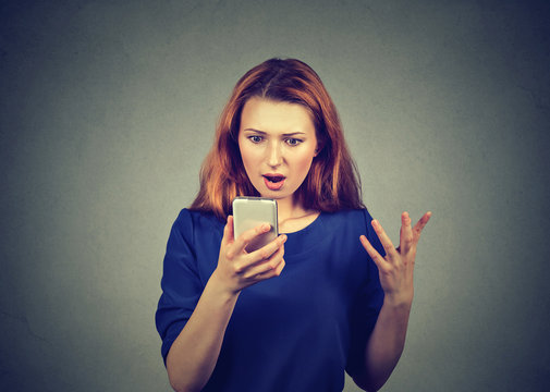 Shocked woman watching news on smartphone