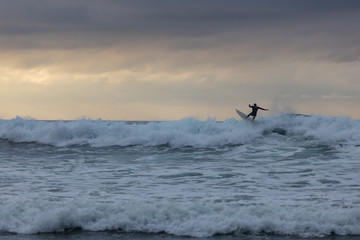 Surfer in the Pacific Ocean Cresting a Wave