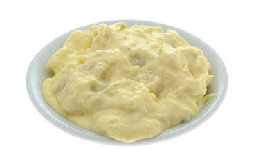 Side view of a portion of potato and egg salad in a small bowl isolated on a white background.