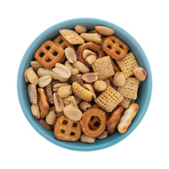 Top view of a small bowl filled with peanuts and an assortment of crunchy pretzels and waffle crackers isolated on a white background.