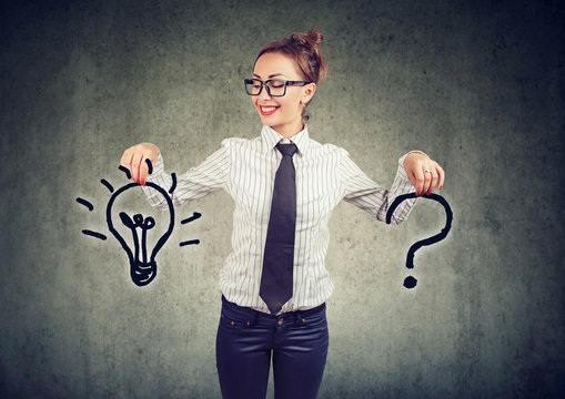 Happy young business woman with question and an answer idea light bulb