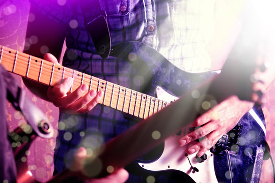 Life style image of close up young male guitarist hand, playing electric guitar