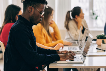 Profile of African American Man Working Next to Colleagues in Br