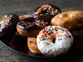 Plate of multi-colored doughnuts 