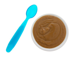 Top view of a serving of mocha instant pudding in a small bowl with a blue plastic spoon to the side isolated on a white background.