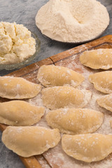 Raw dumplings of dough stuffed with cottage cheese, vertical frame.