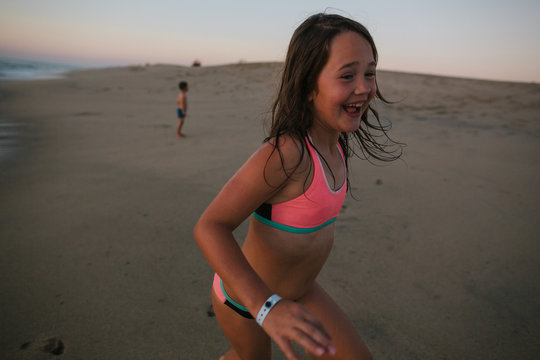 Happy kids playing on sandy beach at sunset