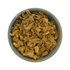 Top view of an old stoneware bowl filled with breaded and fried jalapeno peppers isolated on a white background.