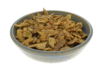Side view of an old stoneware bowl filled with breaded and fried jalapeno peppers isolated on a white background.