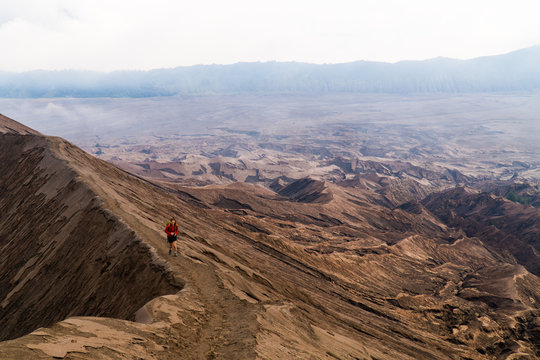 A young woman hiking on the edge of a volcano crater