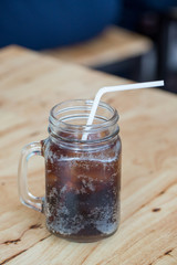 glass of cola with ice with copy-space in composition.Ice soda glass.refresh drink.Cola with crushed ice and straw in glass on white background.
