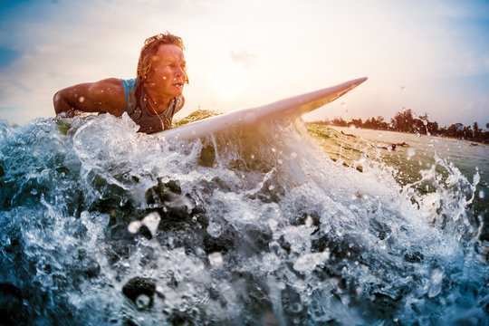 Young Man Surfer Trying To Catch The Wave