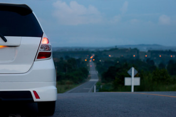 Hatchback car white color stop ton the road on morning trip travel to Country at Rayong Thailand.