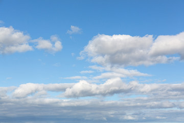 Blue sky with several scattered cumulus clouds.