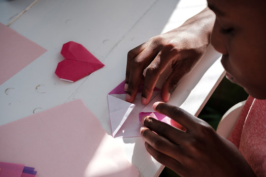 Young boy making heart Origami