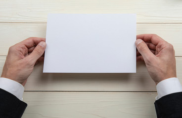 Mens hands holding empty white letterhead